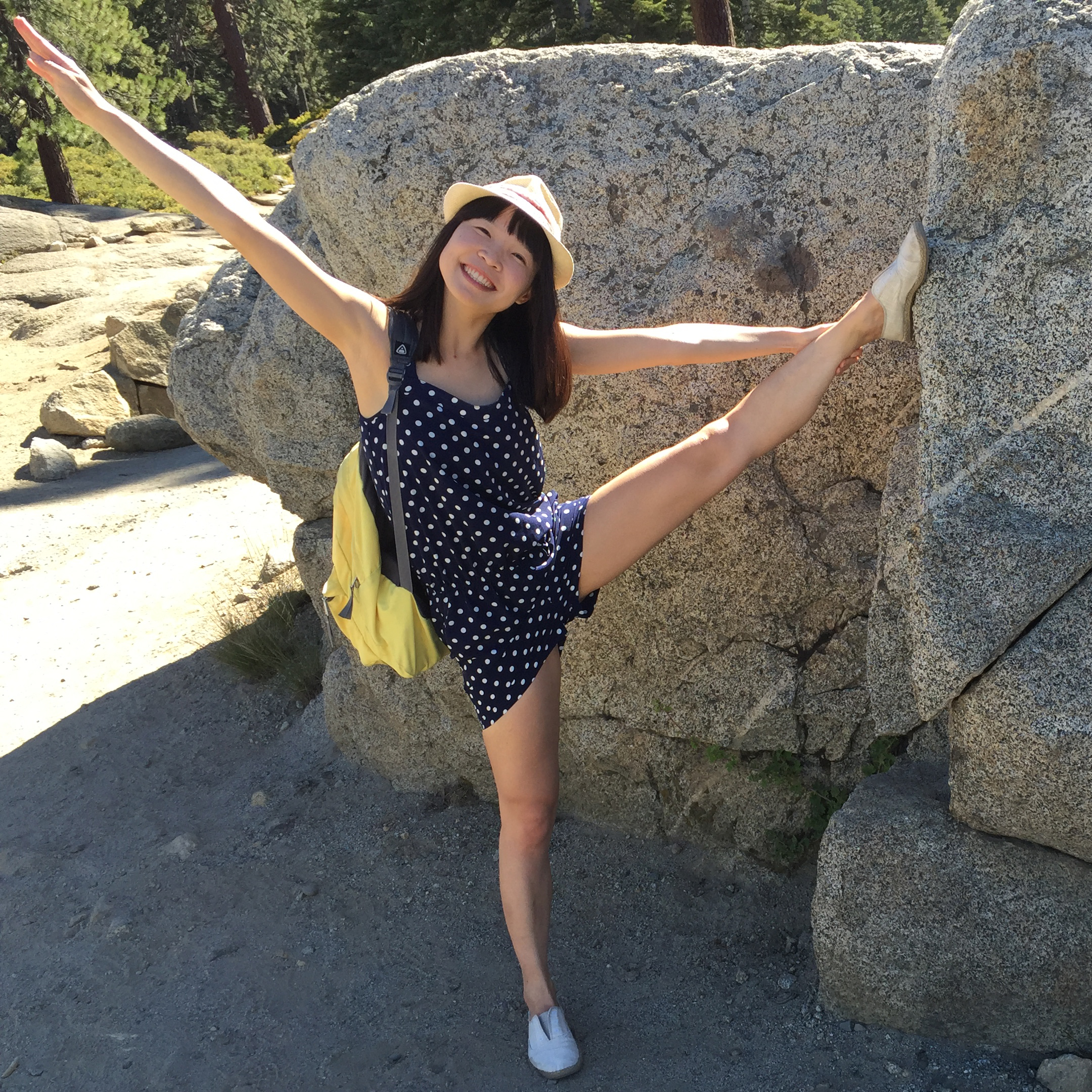 a picture of Tabitha. She puts her leg on a rock about her height up.